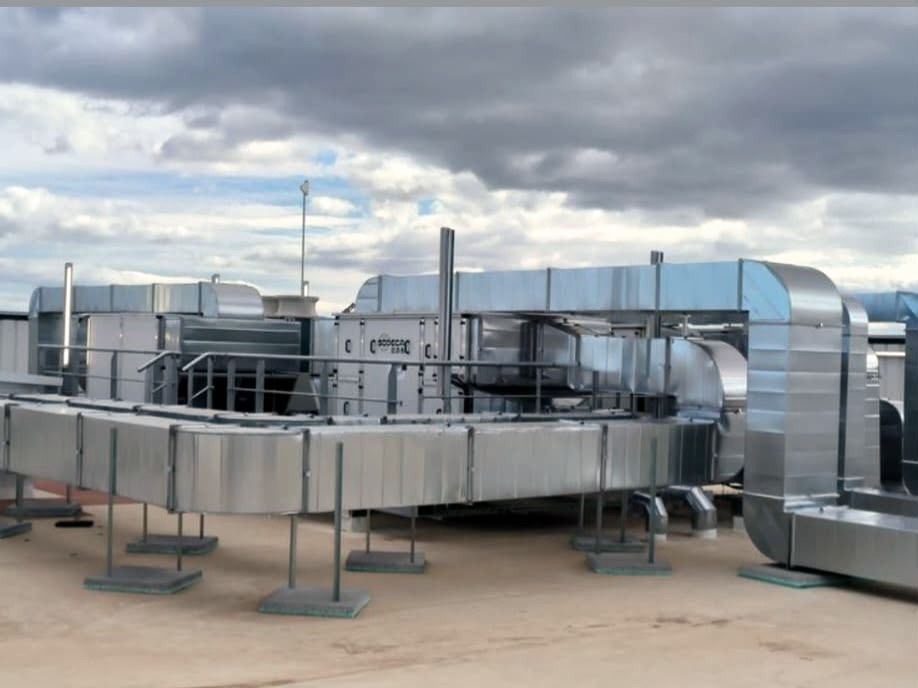 Red de conductos de ventilación de chapa galvanizada en cubierta, sobre soportes, conectada a unidades de tratamiento de aire