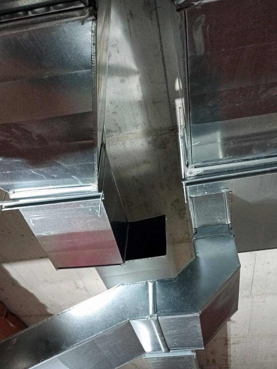 Derivación en Y de conductos de ventilación de chapa galvanizada con junta de brida bajo un forjado de hormigón